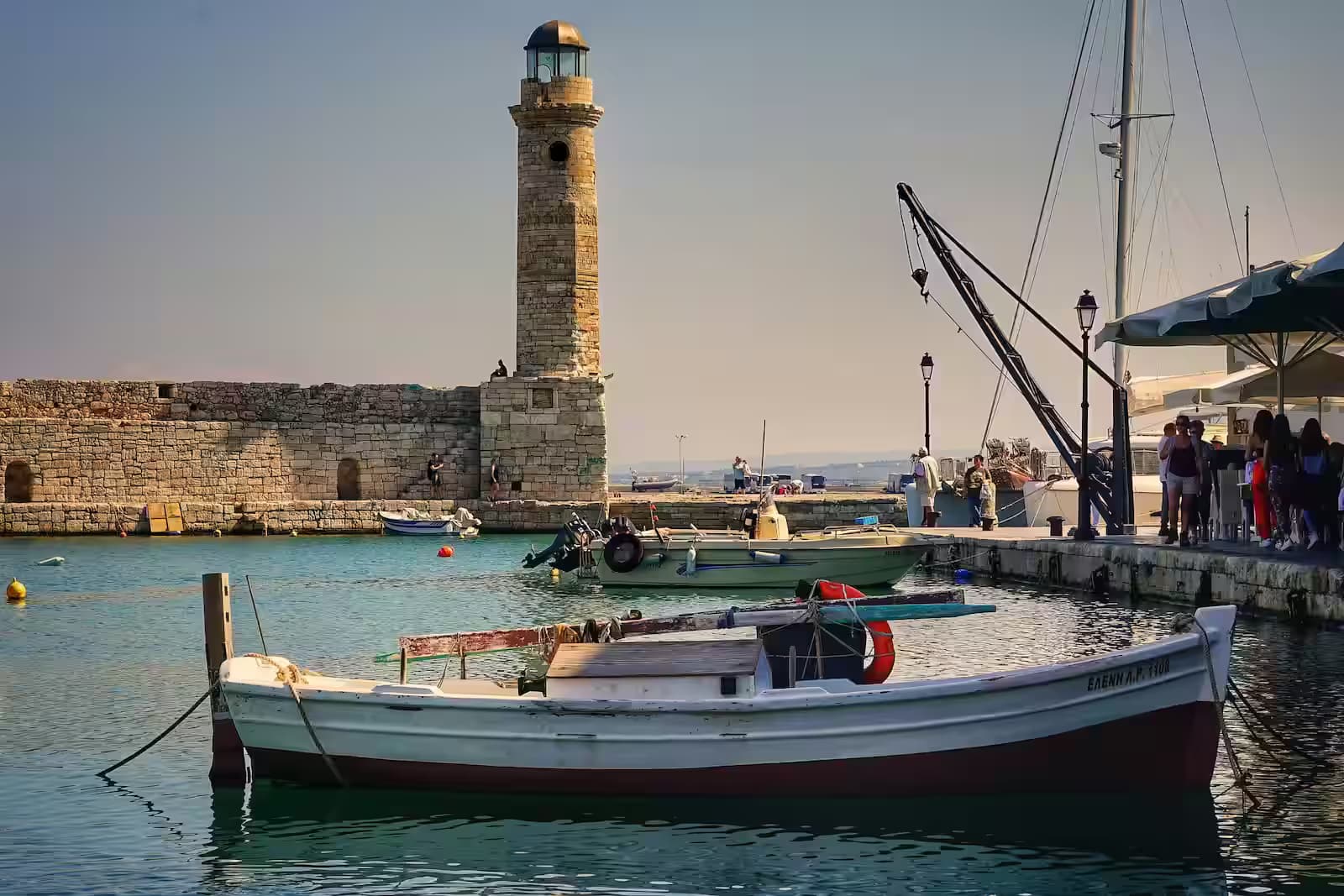 Historic Venetian Lighthouse and traditional fishing boats in the Old Harbor of Rethymno, Crete, Greece