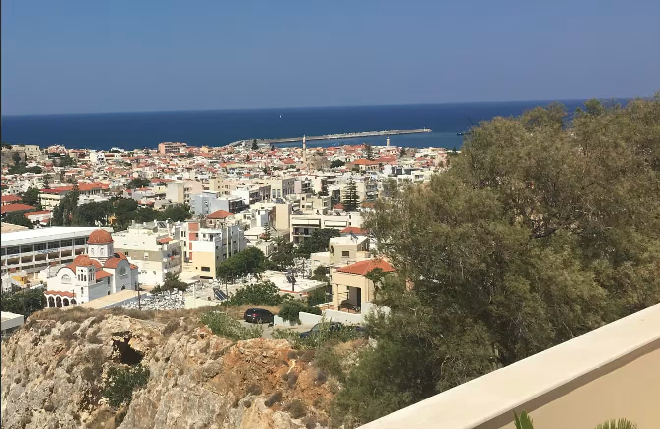 Elevated panoramic view of Rethymno Old Town and city skyline leading to the Venetian harbor and Mediterranean Sea, Crete, Greece