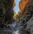 Narrow passage and smooth rock walls inside the dramatic Sarakina Gorge, Ierapetra, East Crete, featuring a rocky stream bed