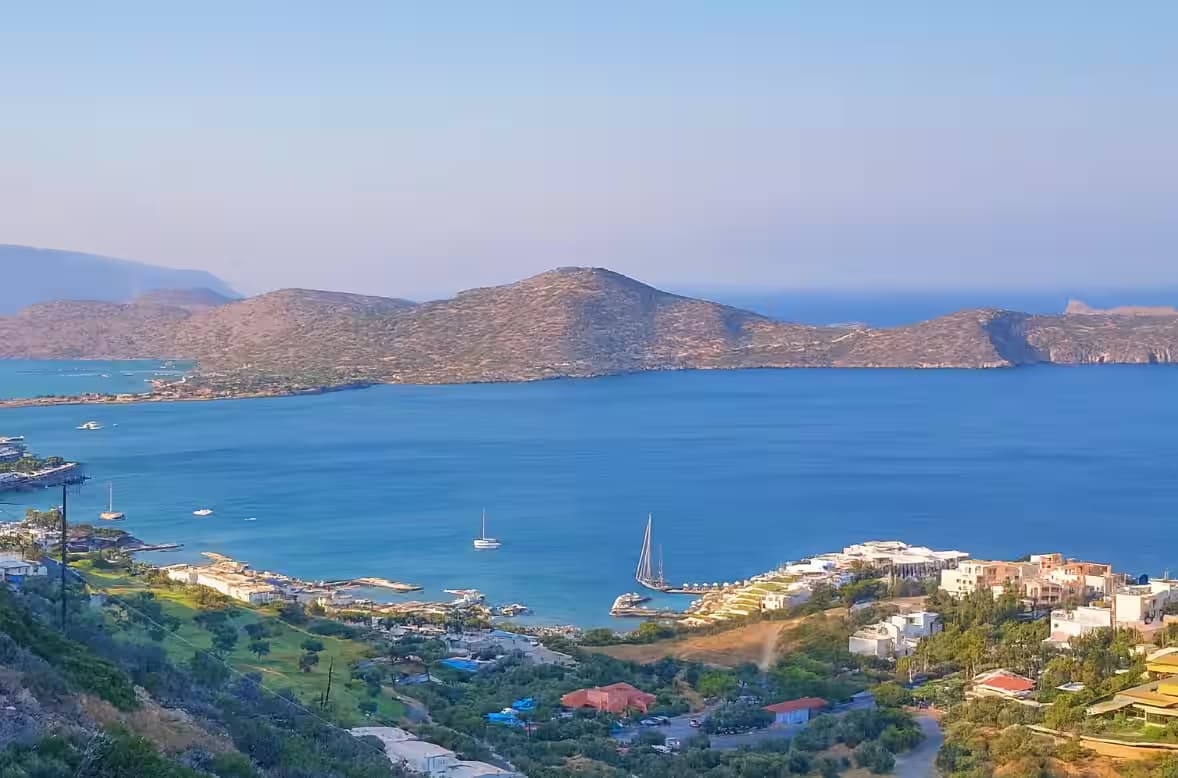 Elevated panoramic view of the luxury resorts and turquoise waters of Elounda and Mirabello Bay, East Crete, Greece