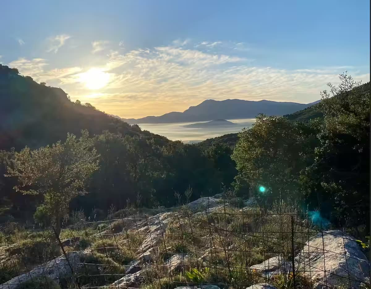 Scenic panoramic view of the fertile Lassithi Plateau framed by mountains at sunrise, East Crete, Greece